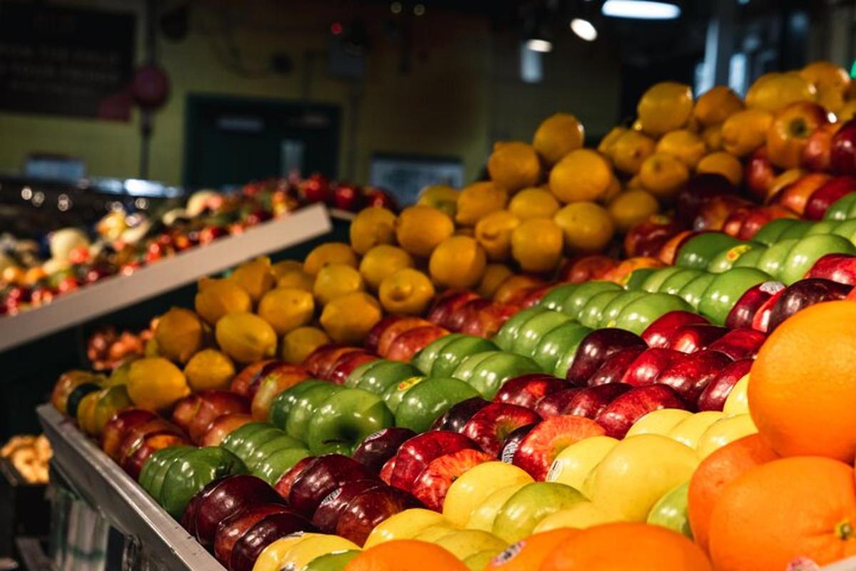 uma exposição de maçãs, laranjas e outras frutas em uma loja