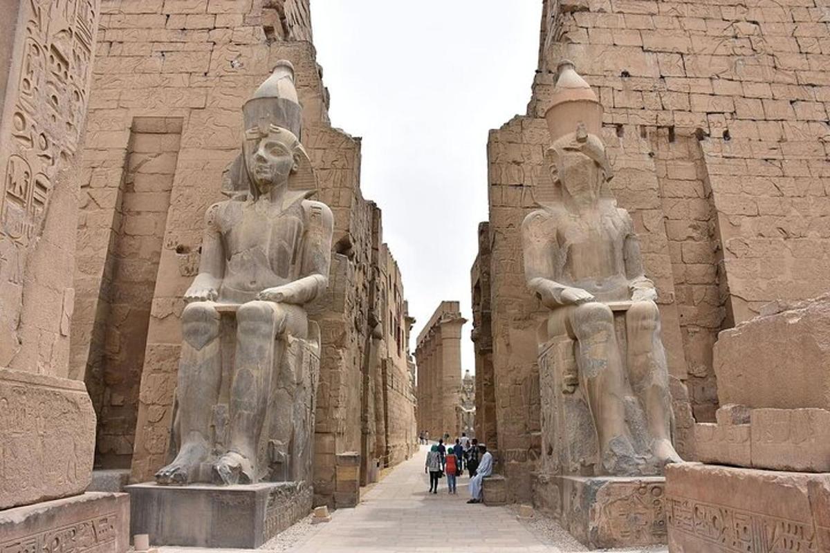 two large statues of people standing next to a building