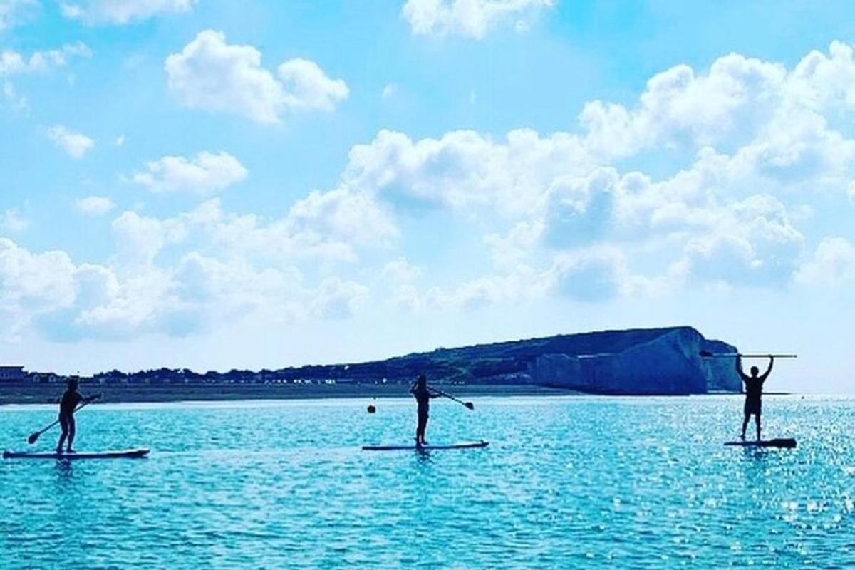 tre persone su tavole da paddle in acqua