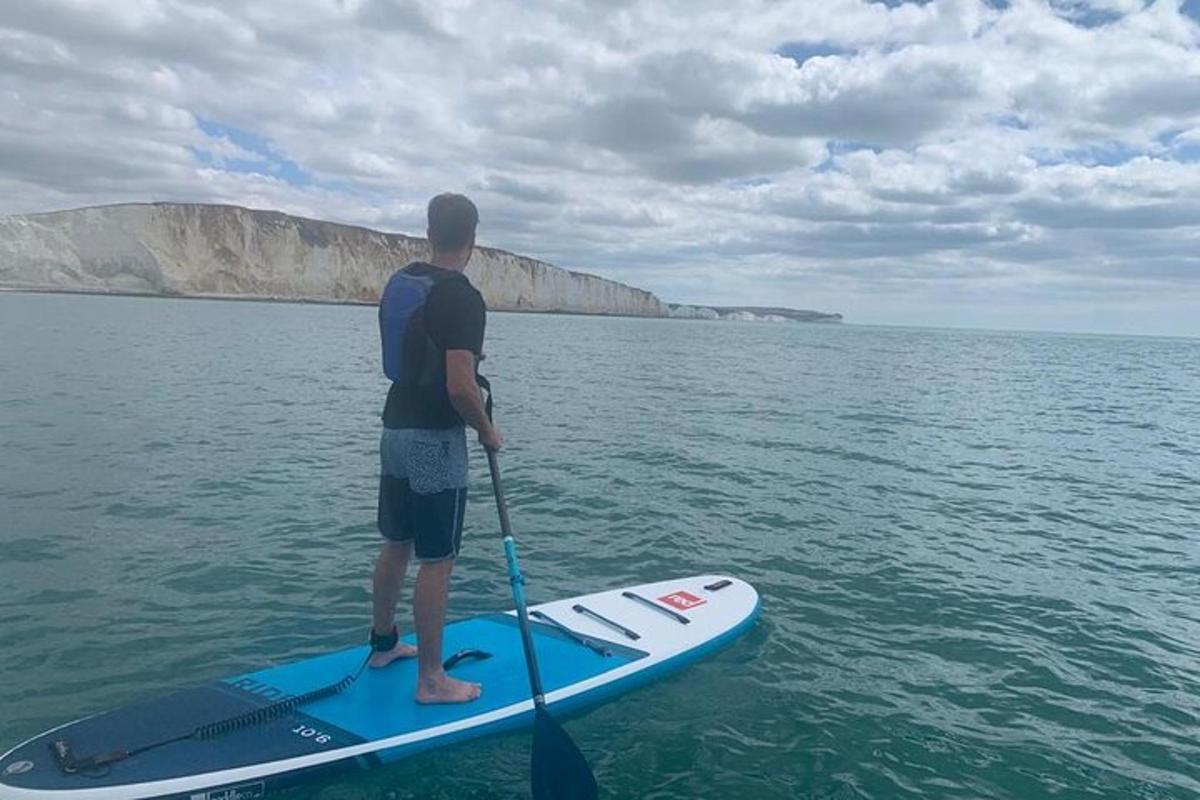 un uomo in piedi su una tavola da paddle in acqua
