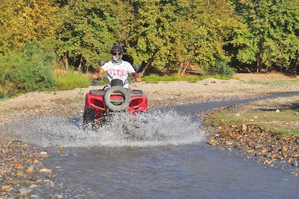 una persona que condueix un quad a l'aigua