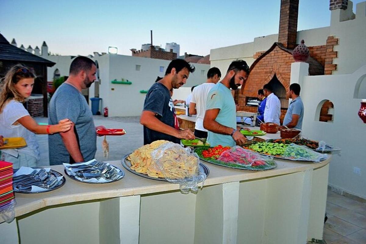 um grupo de pessoas em pé ao redor de uma mesa com comida