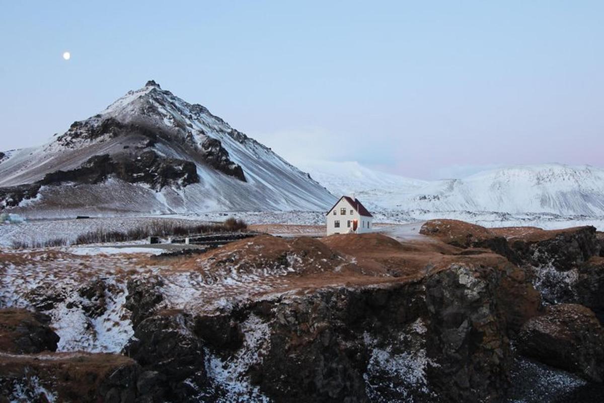 una piccola casa bianca di fronte a una montagna