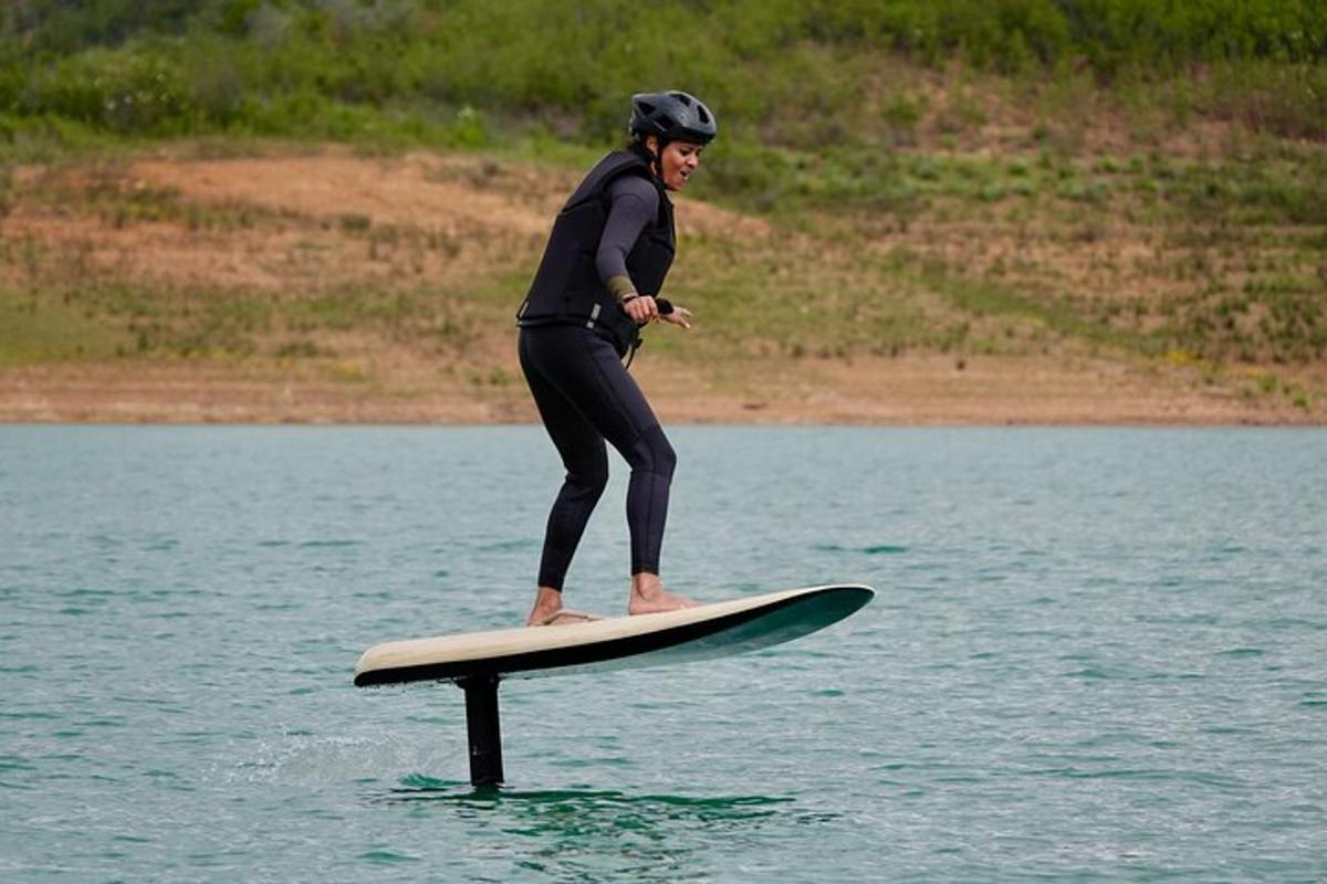Una mujer está parada sobre una tabla de surf en el agua.