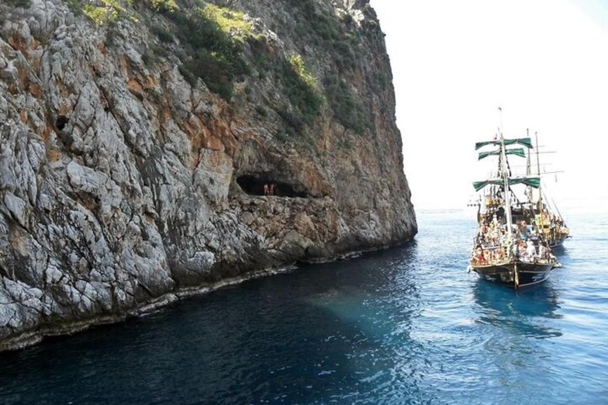μια βάρκα στο νερό δίπλα σε έναν απότομο βράχο