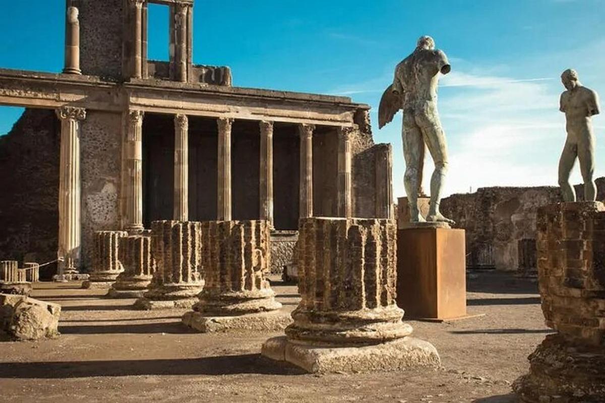 ένα άγαλμα ενός άνδρα σε ένα βάθρο μπροστά από ένα κτίριο