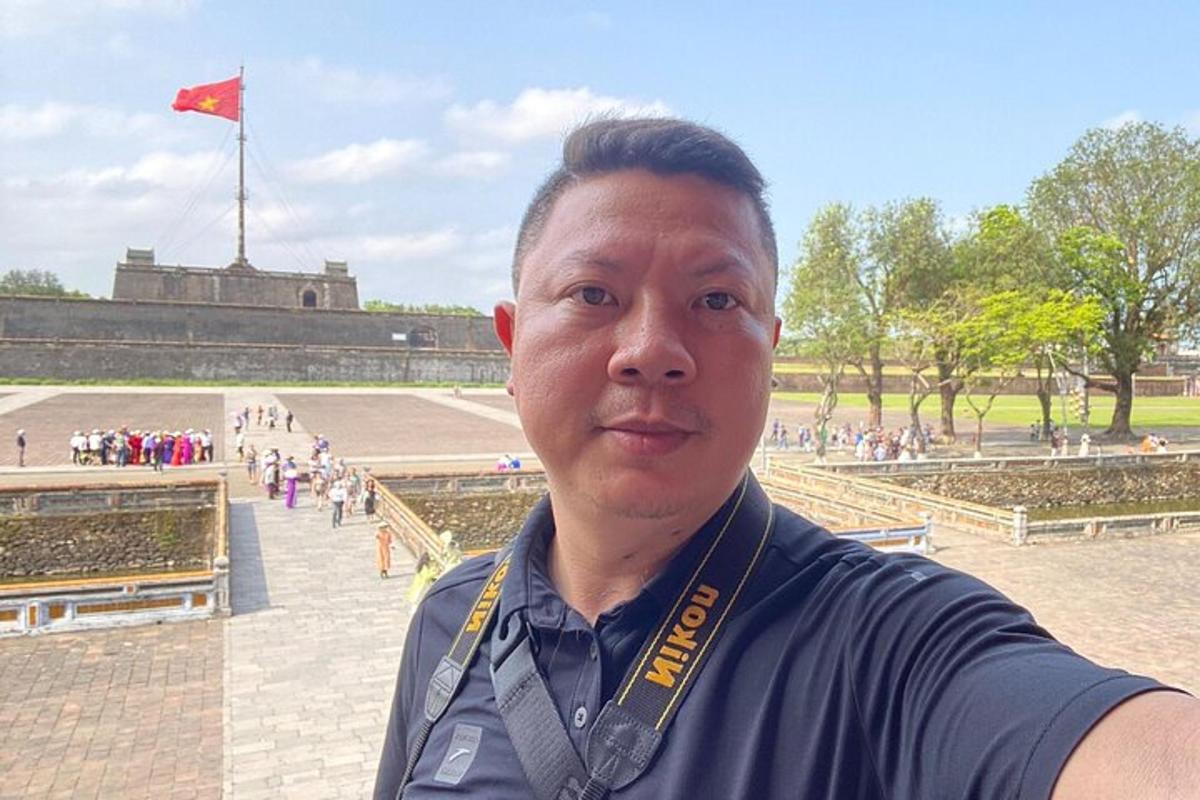 一名脖子上挂着奖章的男子站在公园里