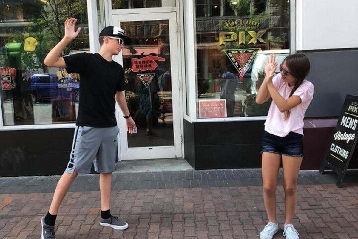 dva lidé stojící na chodníku před obchodem
