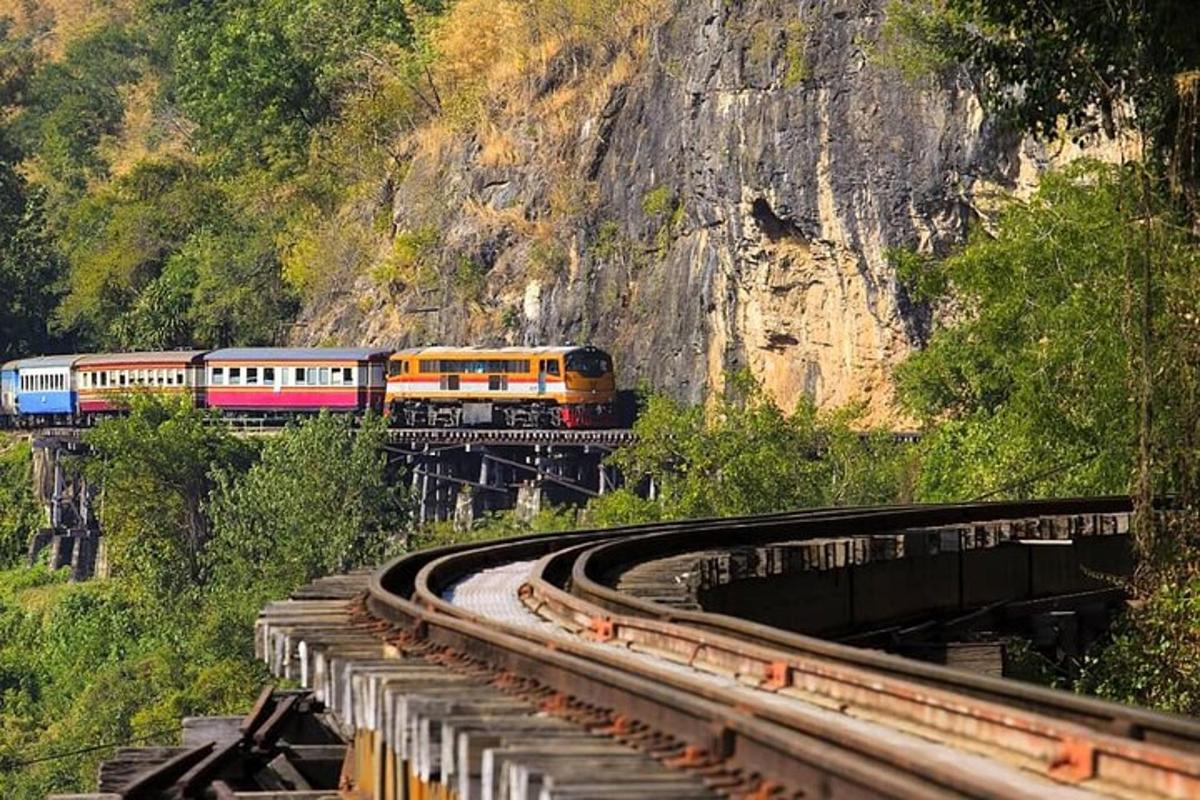 a train on a track with a mountain in the background