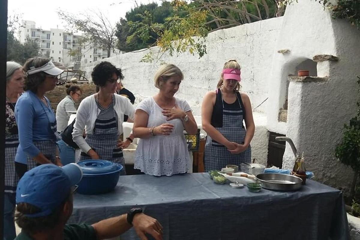 Un grupo de mujeres de pie alrededor de una mesa con comida.