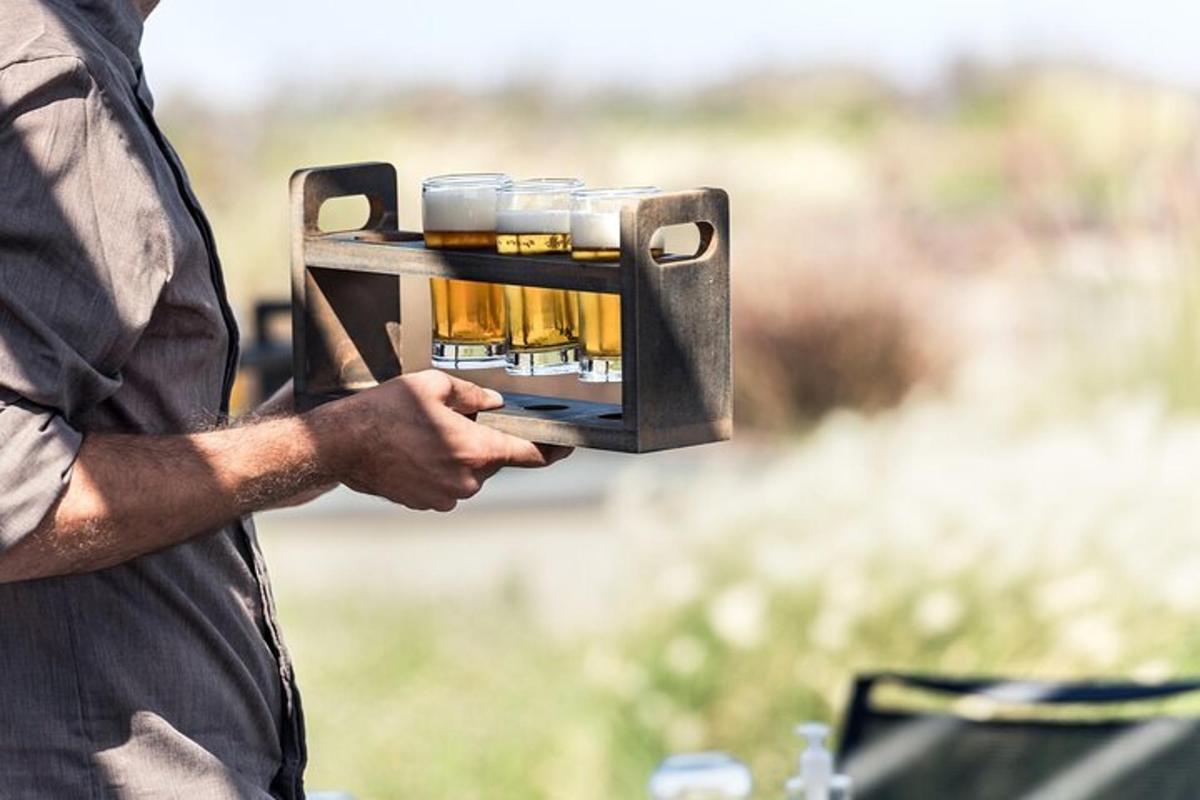 un uomo che tiene in mano un vassoio di bicchieri di birra