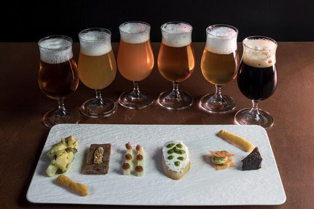 un piatto di cibo e quattro bicchieri di birra