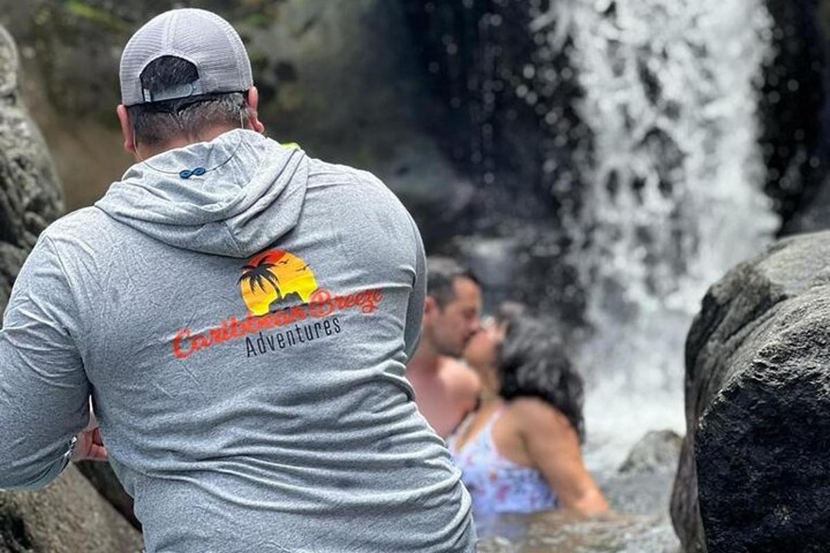 a man and a woman in the water near a waterfall