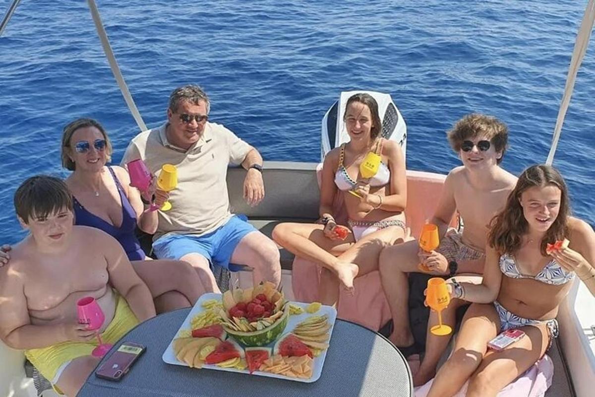skupina lidí sedících kolem stolu na lodi