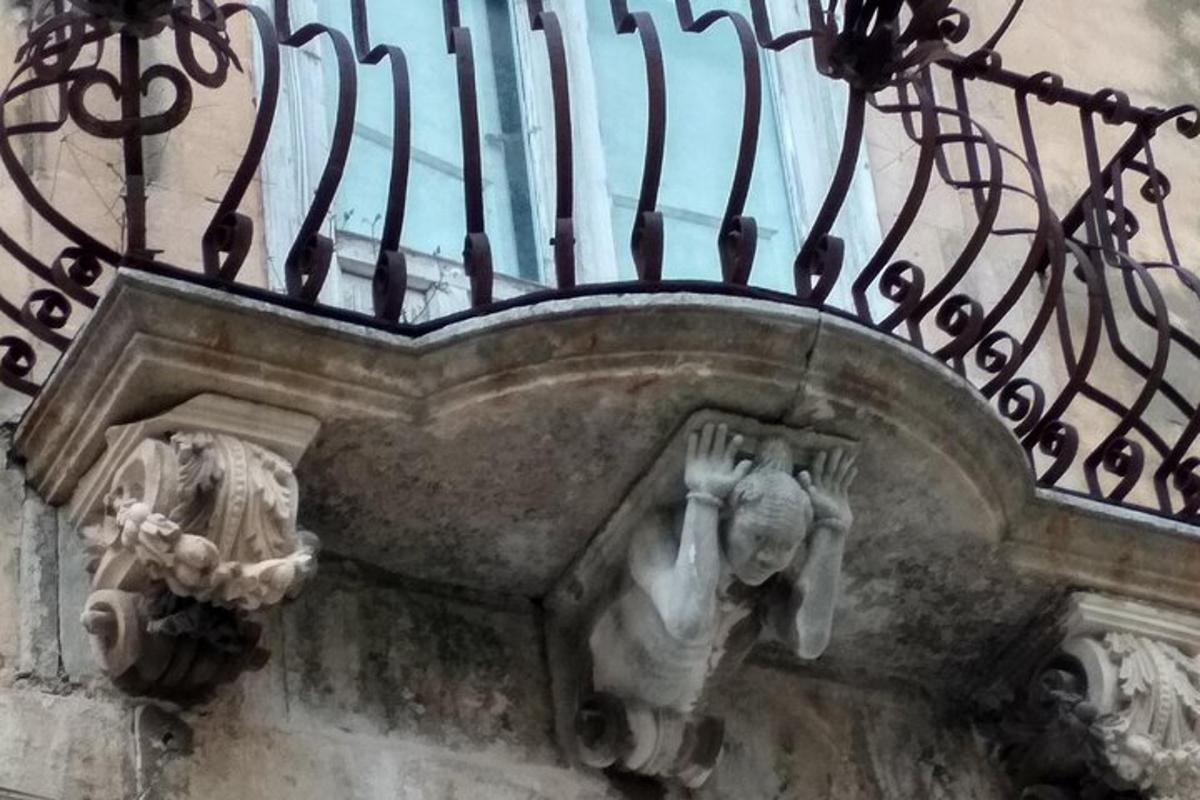 a statue of a person under a balcony