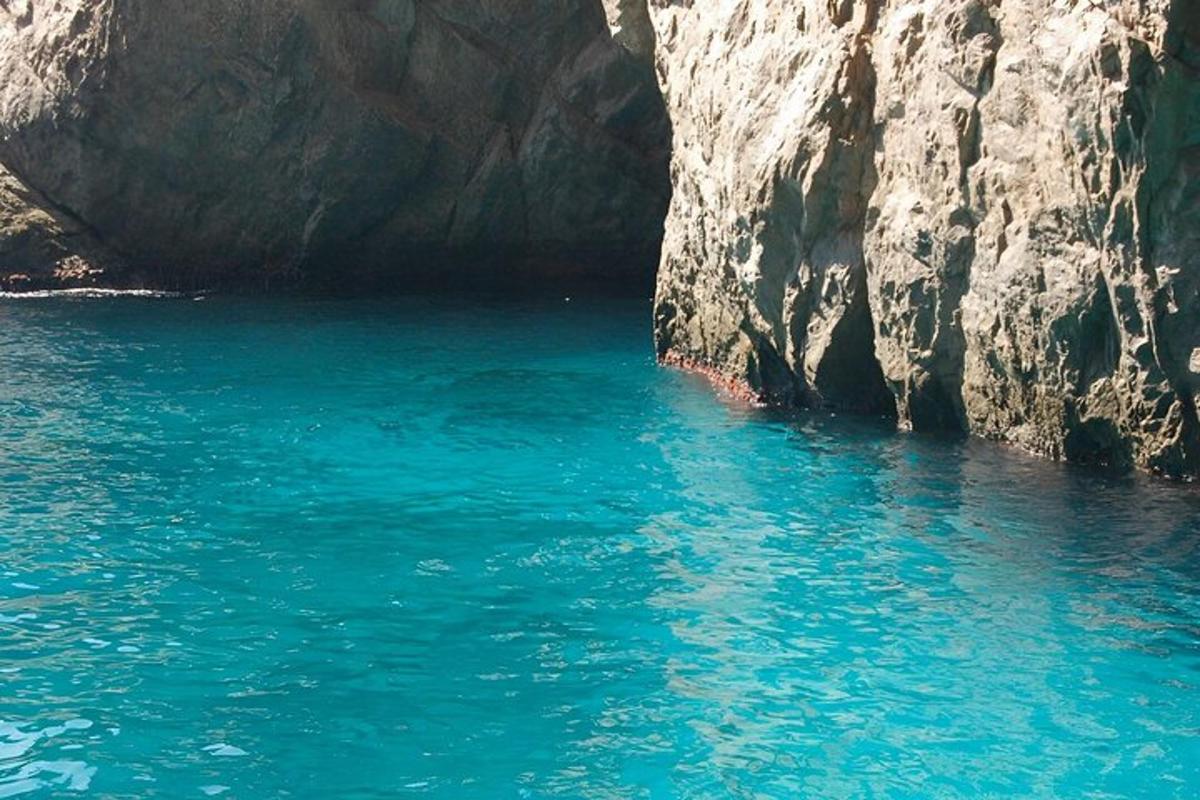 un grande specchio d'acqua accanto a una scogliera rocciosa