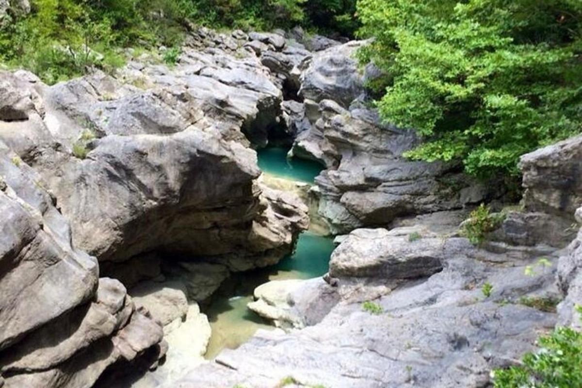 a pool of green water in the middle of rocks