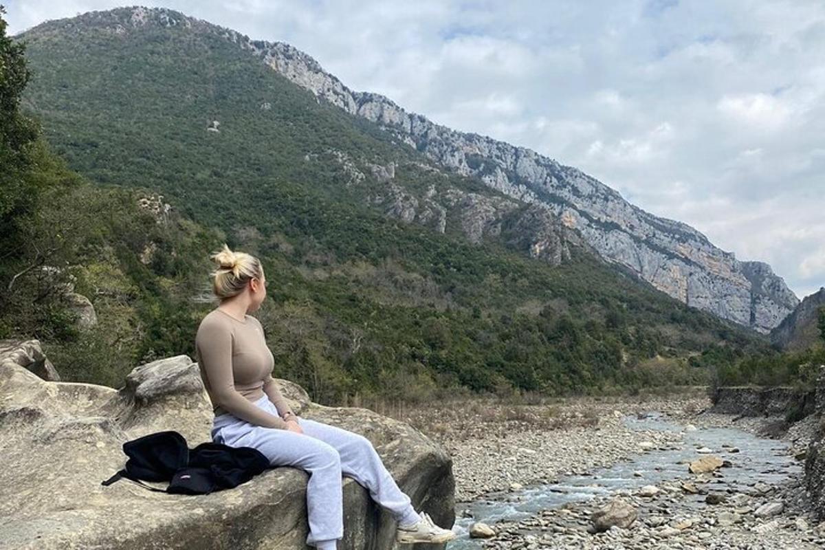 žena sediaca na skale s výhľadom na rieku