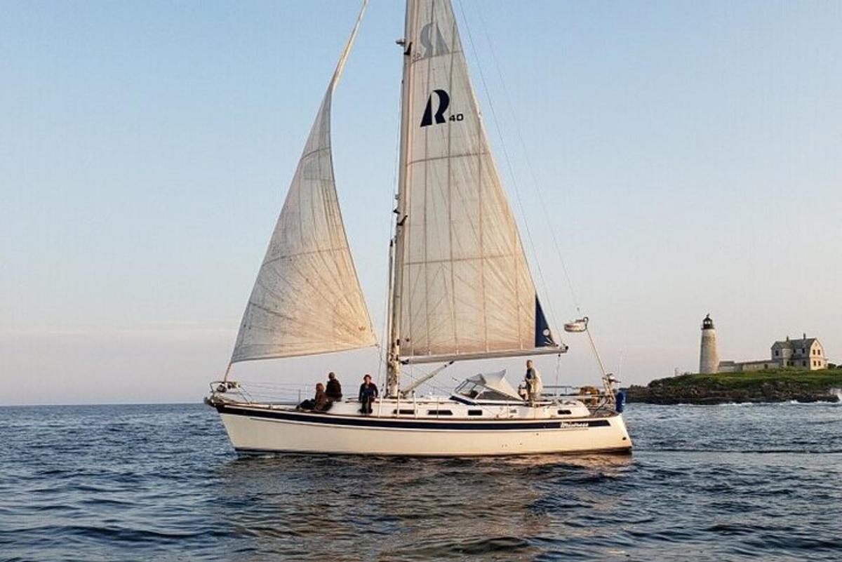 a sailboat with people on it in the water