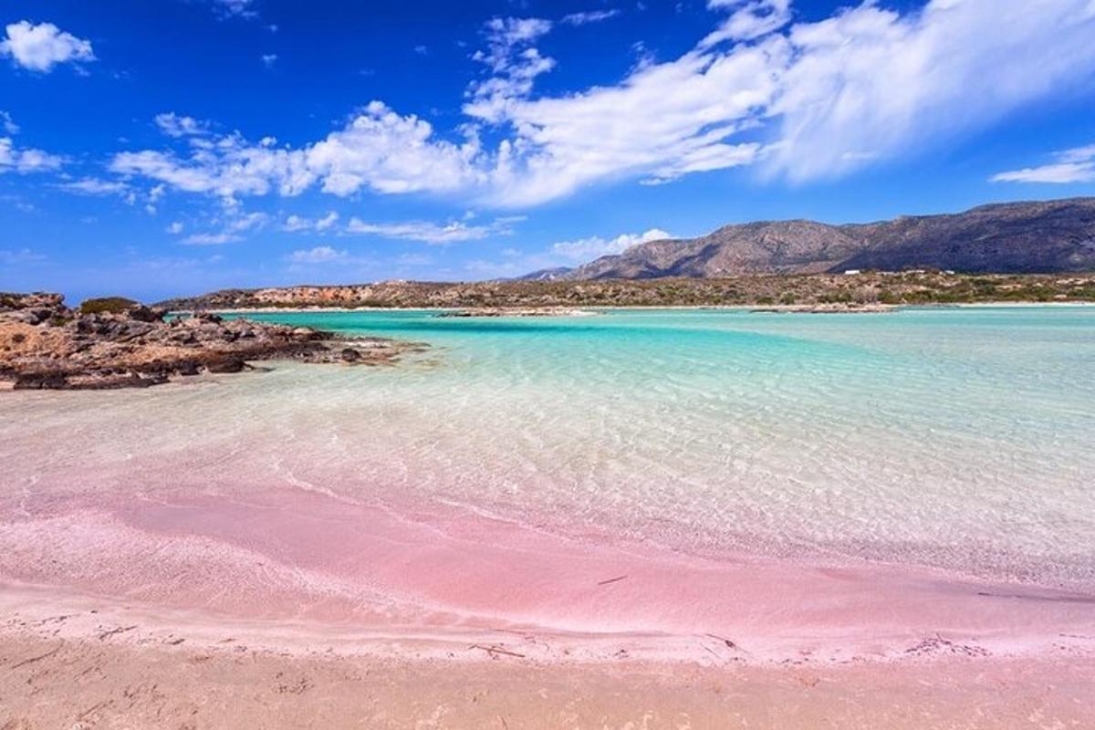 una platja amb aigües cristal·lines i muntanyes al fons