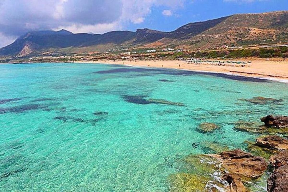una platja amb aigües turqueses i muntanyes al fons