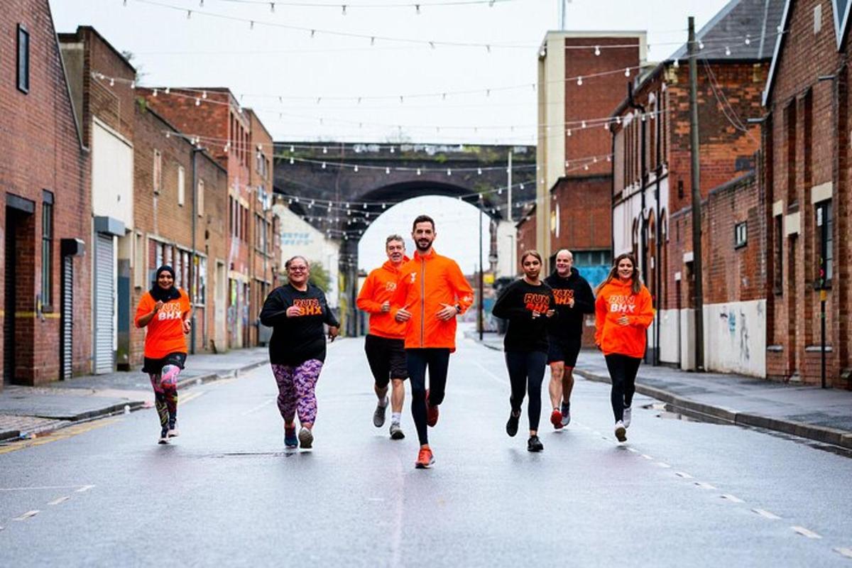 um grupo de pessoas com camisas laranja correndo pela rua