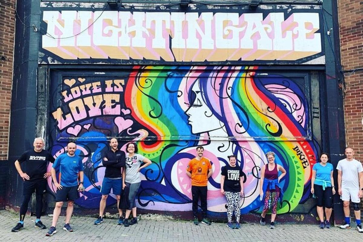 um grupo de pessoas em pé em frente a um mural