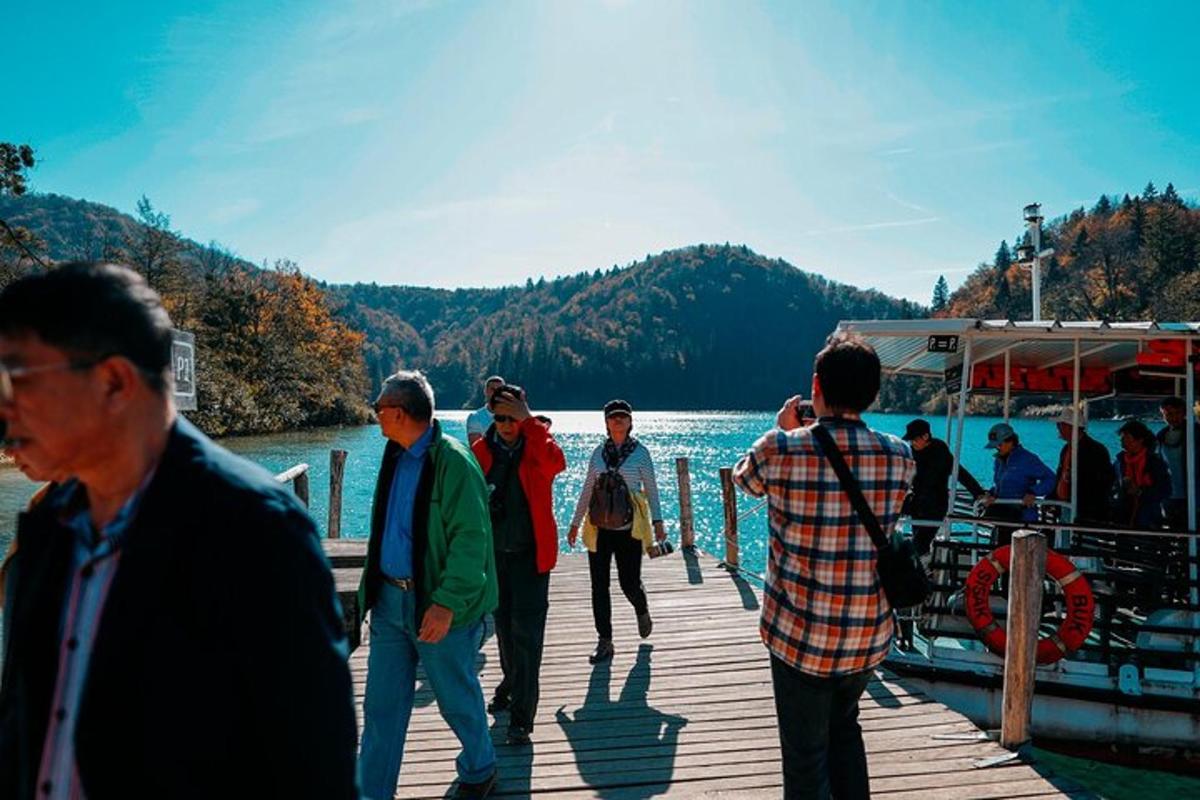 a group of people standing on a dock near the water