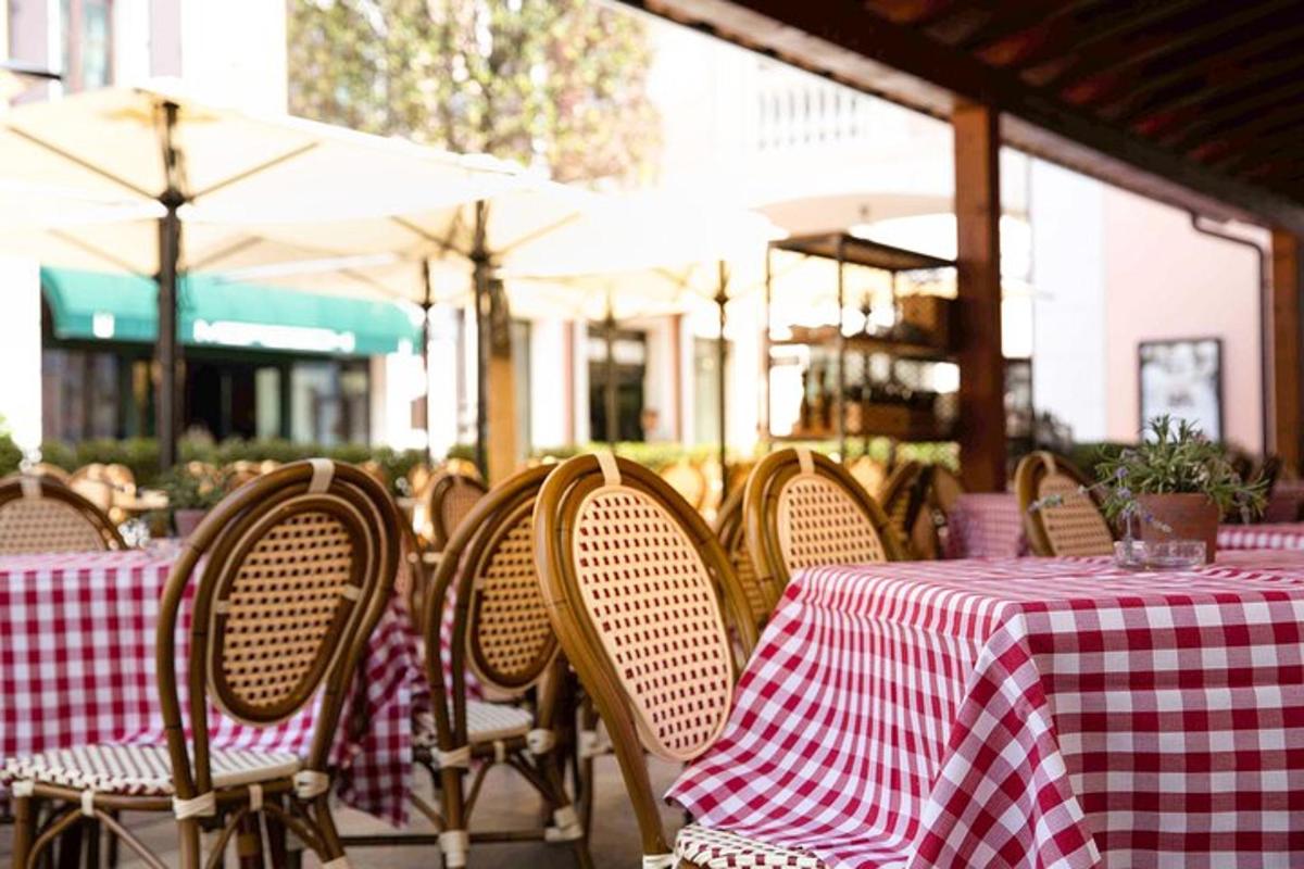μια σειρά από τραπέζια και καρέκλες με κόκκινα και άσπρα τραπεζομάντιλα