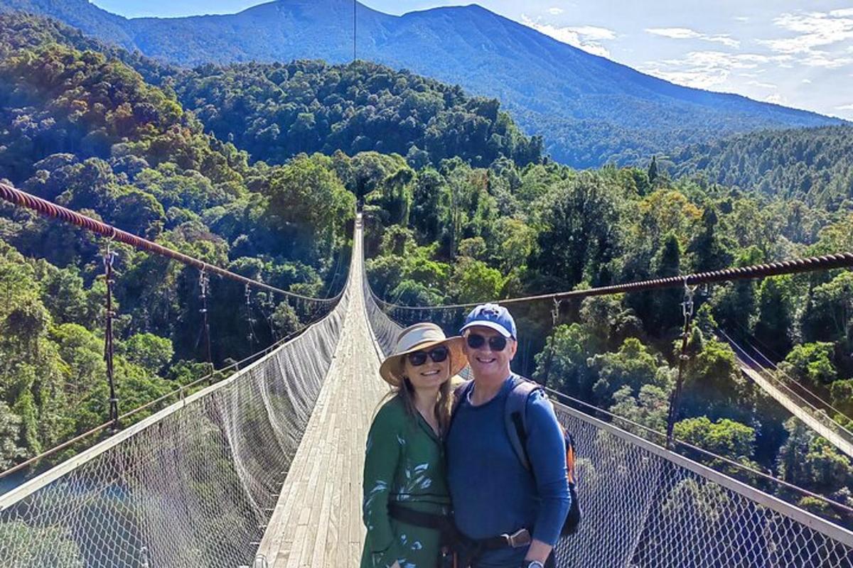 um homem e uma mulher em pé em uma ponte suspensa