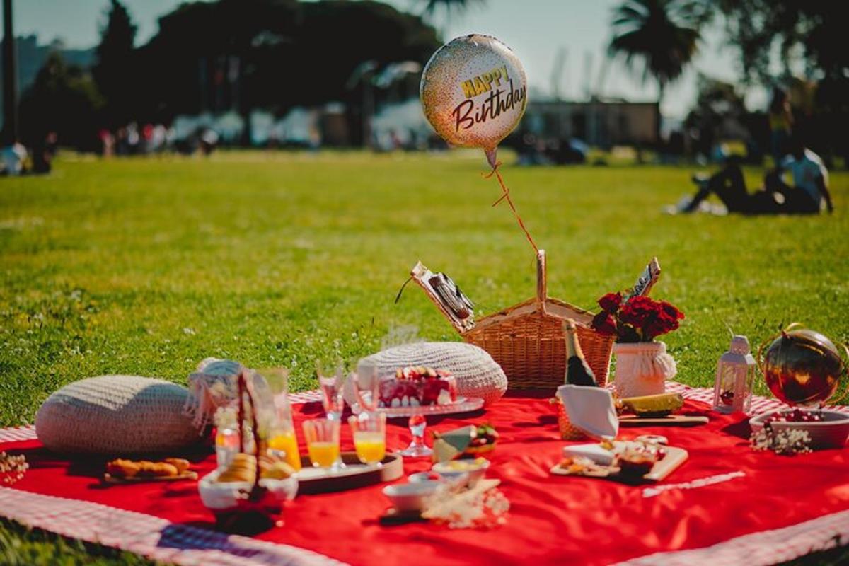 en piknik med en ballong og mat på et rødt teppe