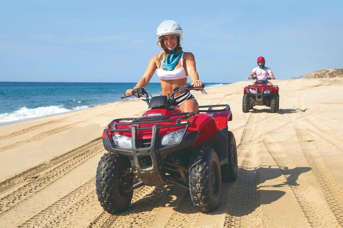 dua orang menaiki atv di pantai