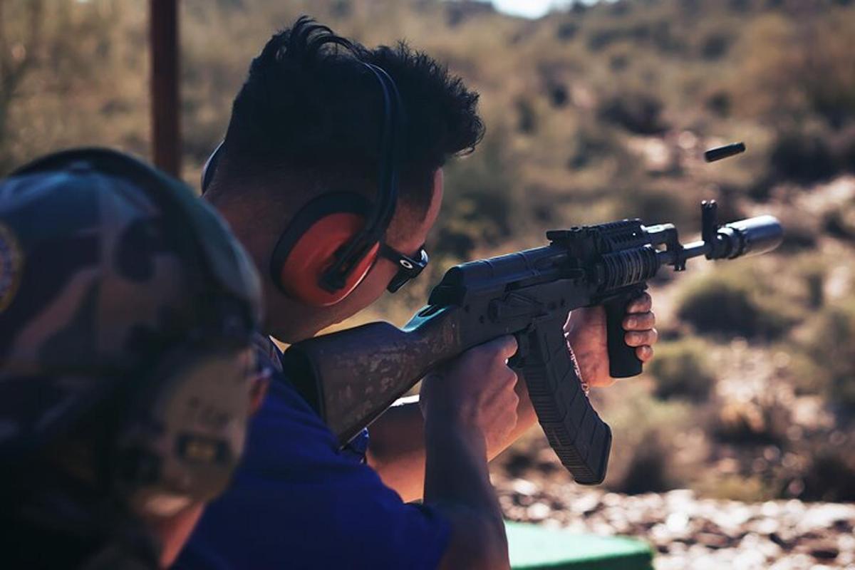 Un hombre sosteniendo un arma frente a una mujer
