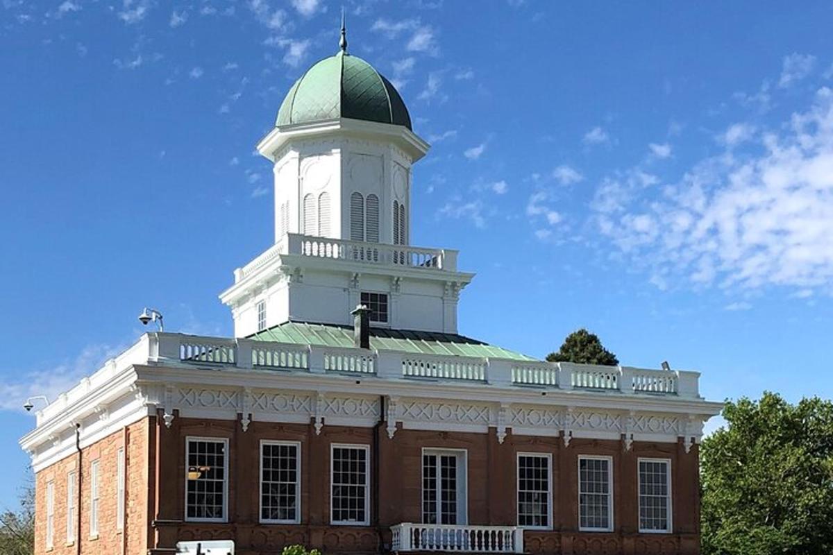 a large brick building with a green and white tower