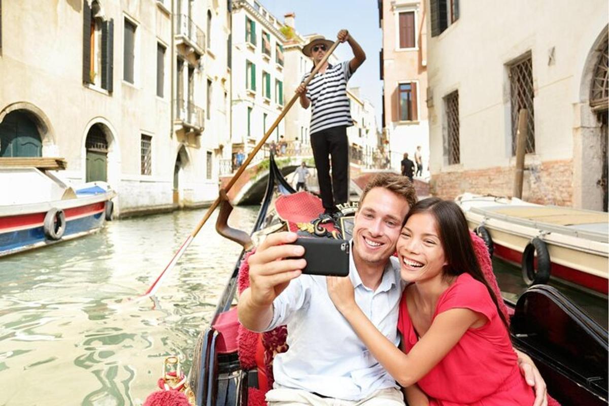 un uomo che scatta una foto a una donna su una gondola