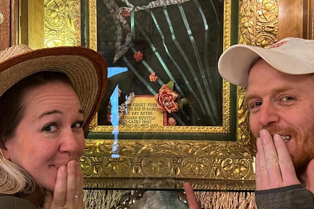 a man and a woman with their faces in front of a painting