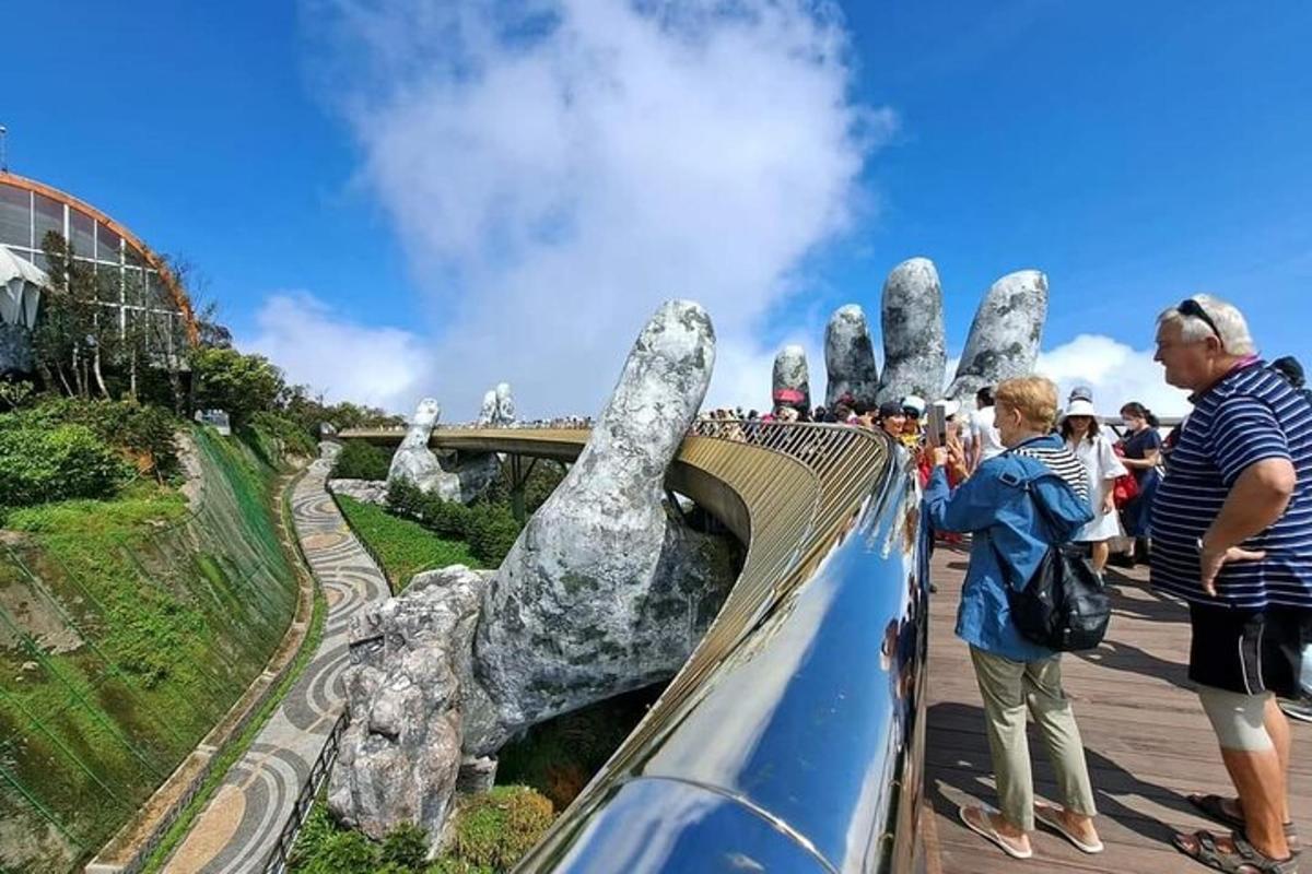 um grupo de pessoas em pé em uma montanha-russa com uma mão gigante