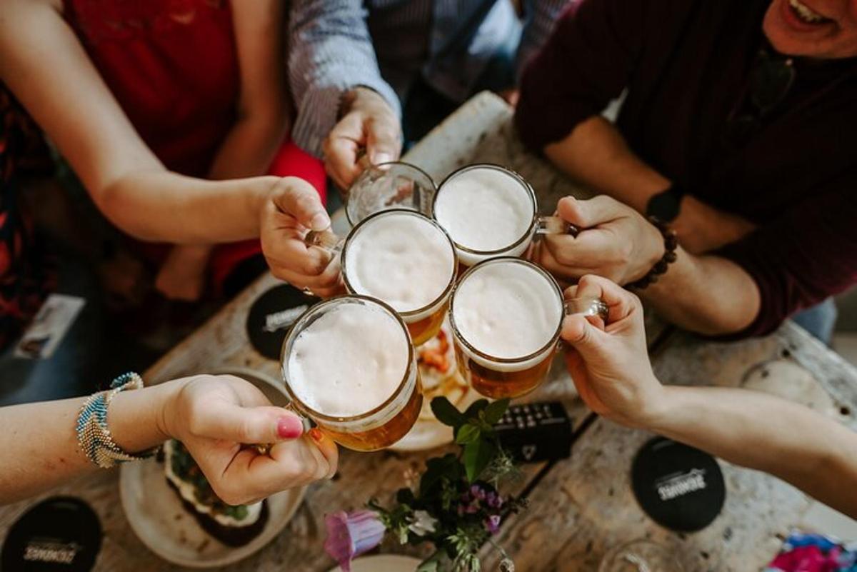 un gruppo di persone sedute attorno a un tavolo a bere birra