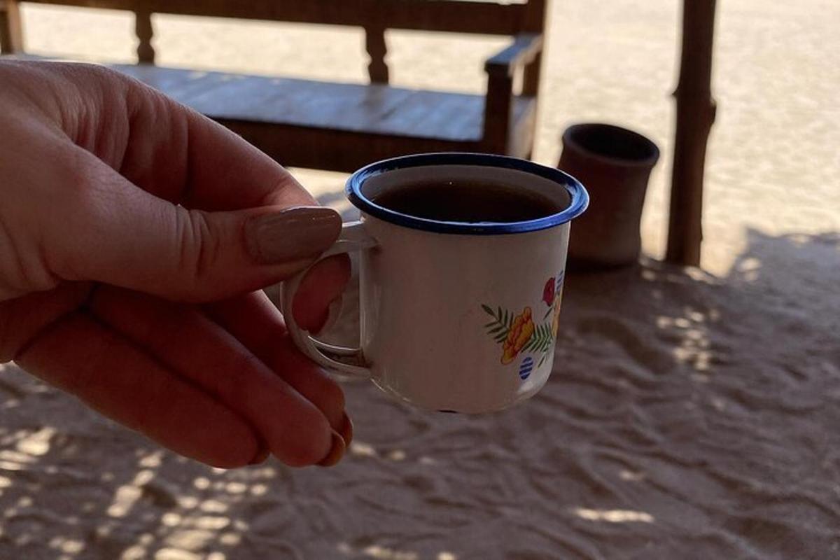 isang taong may hawak na tasa ng kape sa mesa