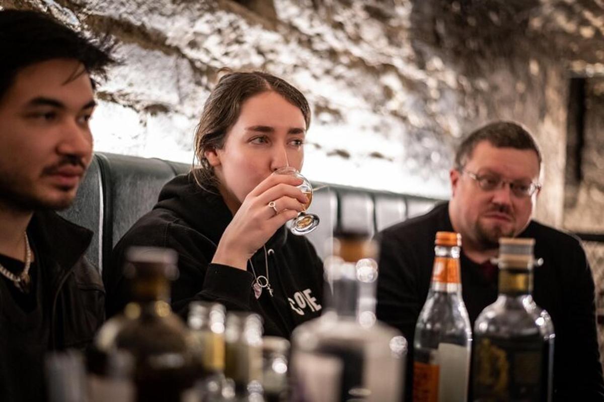 três homens sentados à mesa bebendo vinho