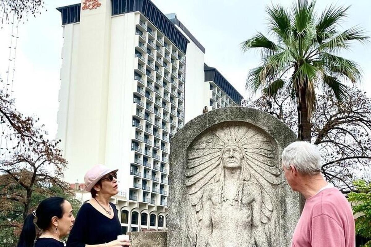 μια ομάδα ανθρώπων που στέκονται γύρω από ένα άγαλμα μπροστά από ένα κτίριο