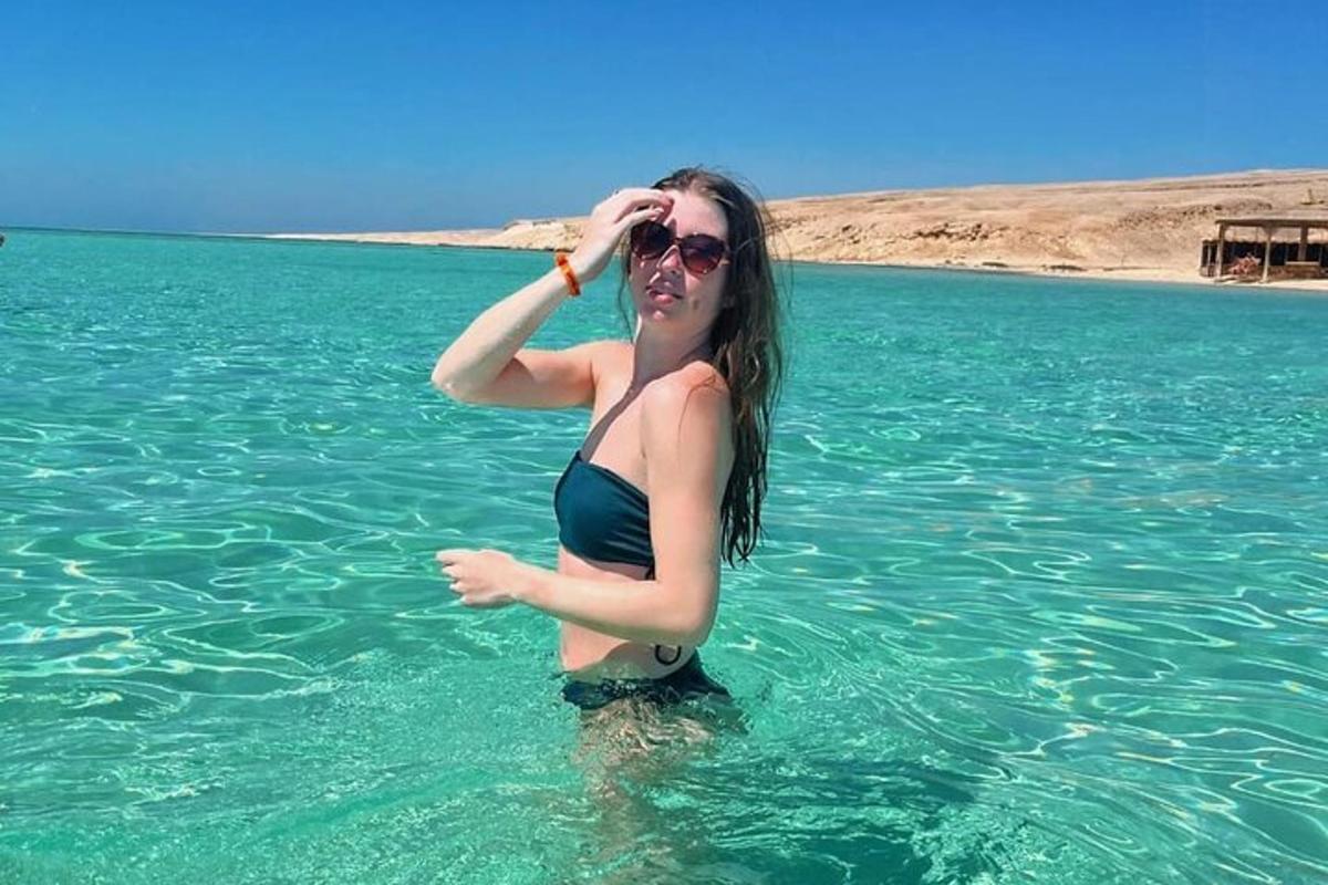kona í vatni í bikiní og sólgleraugu