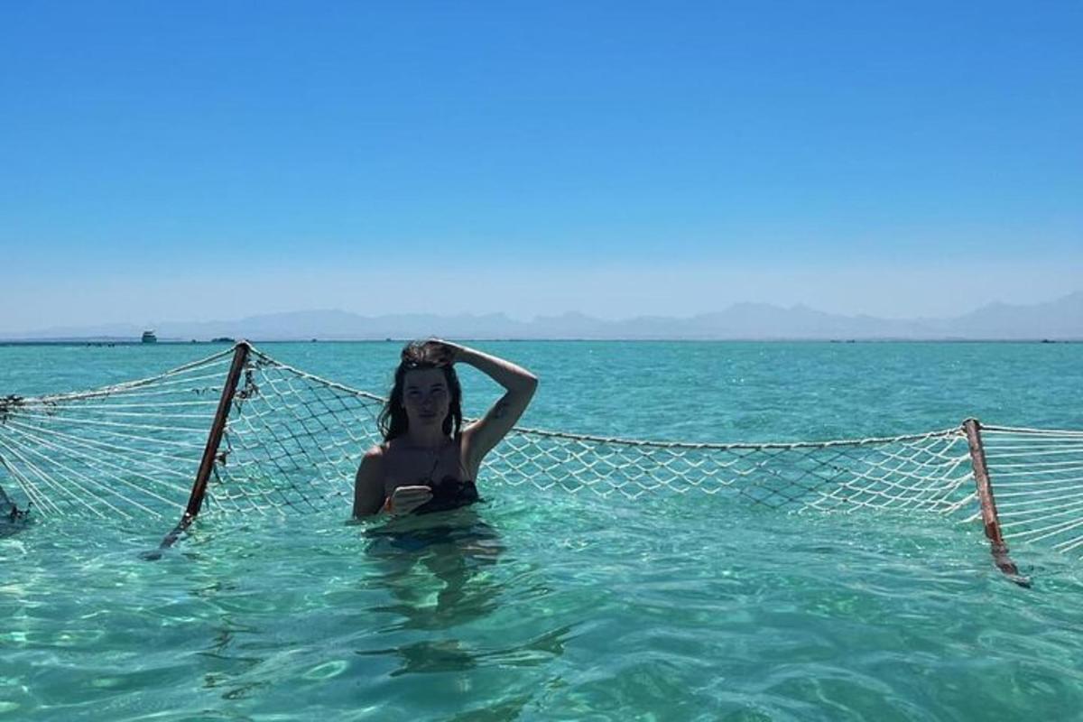 uma mulher deitada em uma rede na água