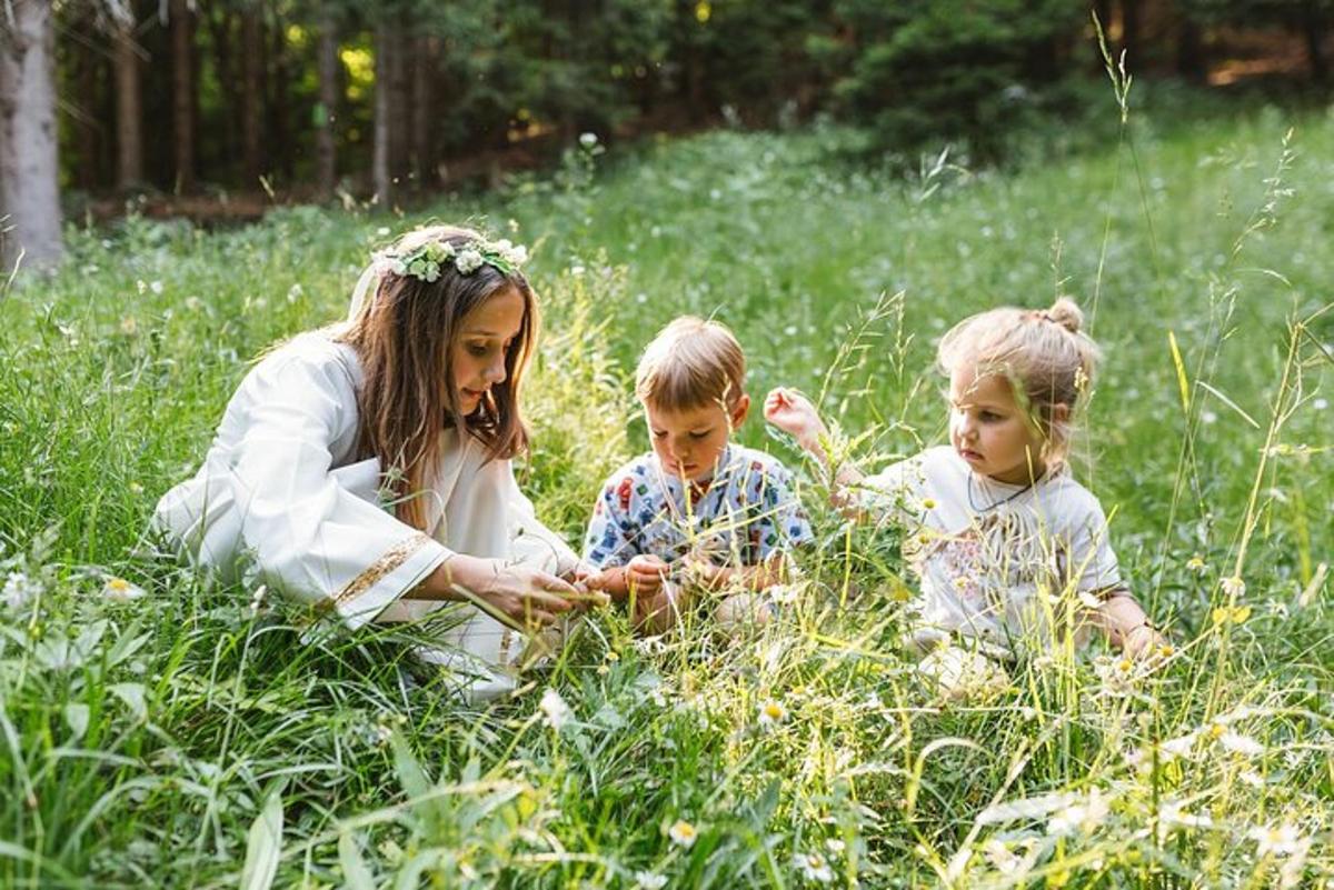 una donna e due bambini seduti sull'erba