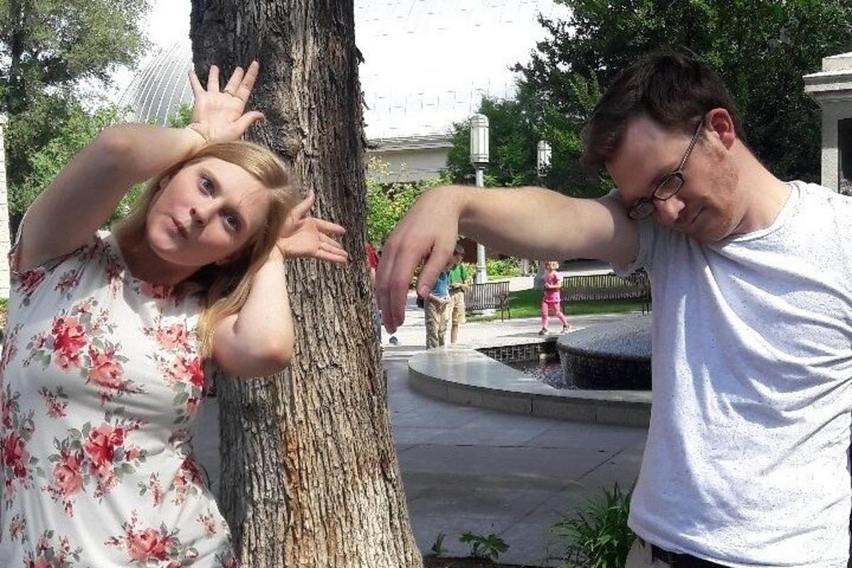 un uomo e una donna in piedi accanto a un albero