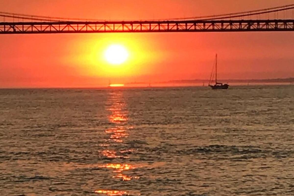 una barca in acqua sotto un ponte al tramonto