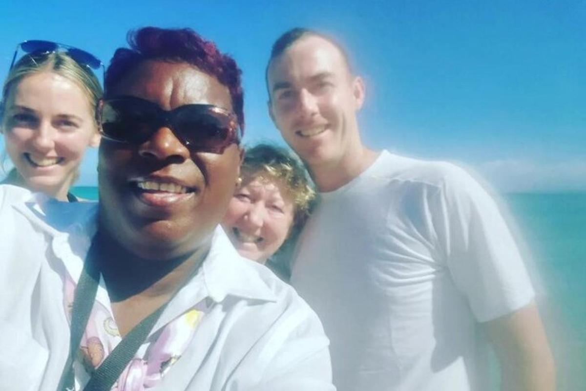 un gruppo di persone in posa per una foto sulla spiaggia