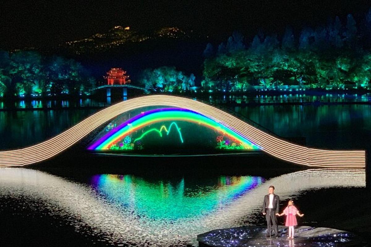 a bridge over a lake at night with a rainbow