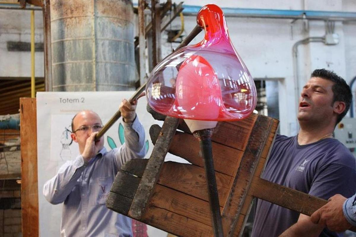 两个男人正在架子上加工一个玻璃物体