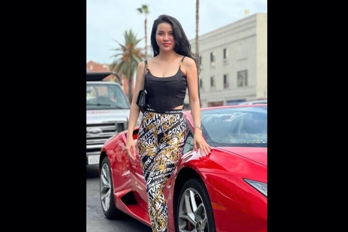 una mujer parada junto a un auto rojo